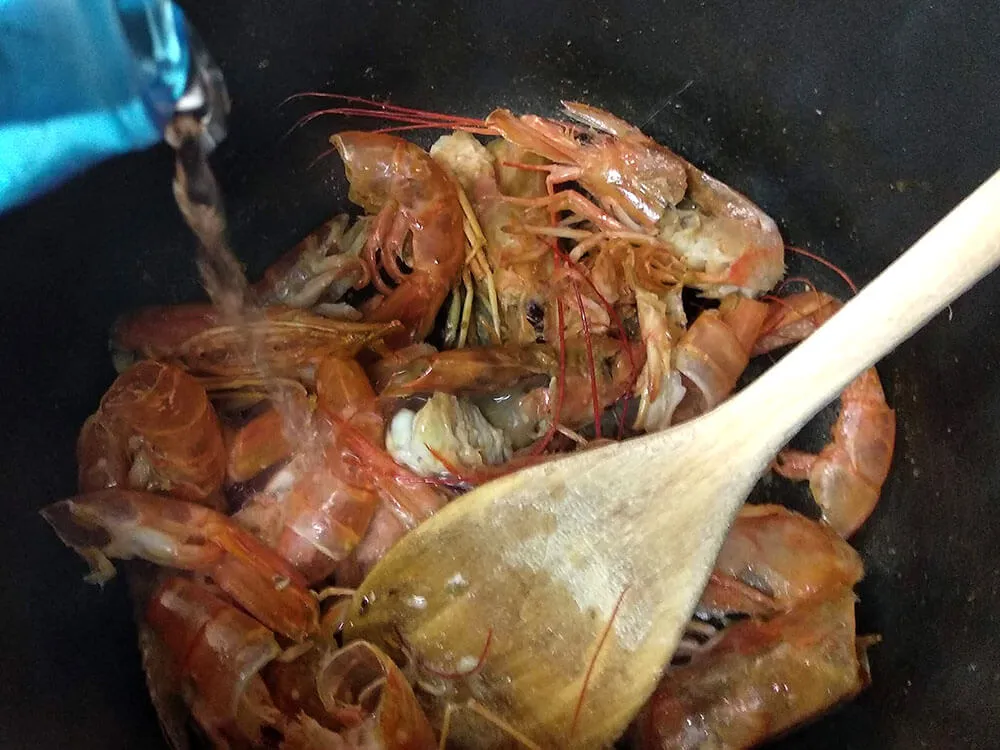 Cáscaras y cabezas de las gambas peladas cocinándose.