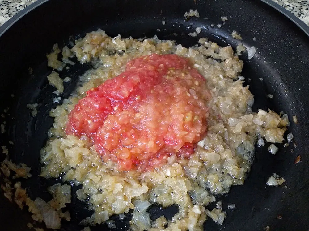 Cebolla pochada y tomate natural rallado.