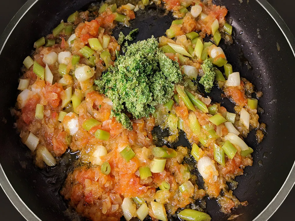 Sofrito de cebolla, tomate y ajos tiernos con picada.