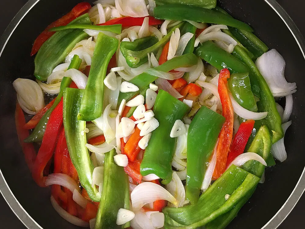 Tiras de pimiento, cebolla en juliana y ajos laminados