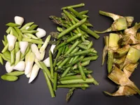 Ajos tiernos, espárragos verdes y alcachofas cortados