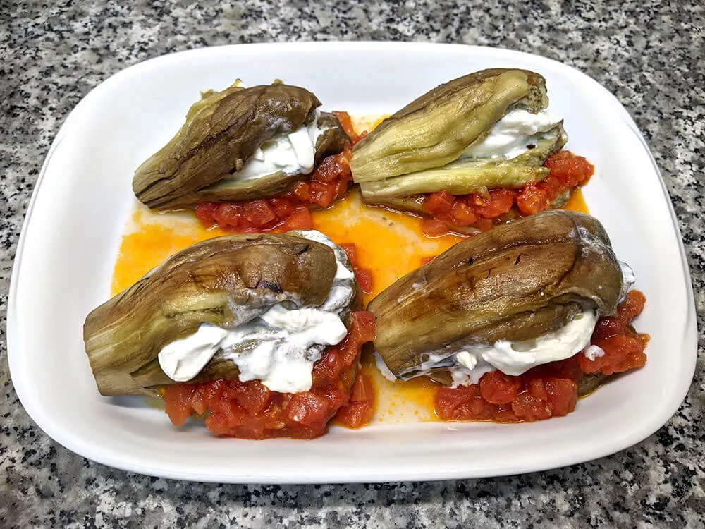 Berenjena horneada rellena con sofrito de tomate y burrata.