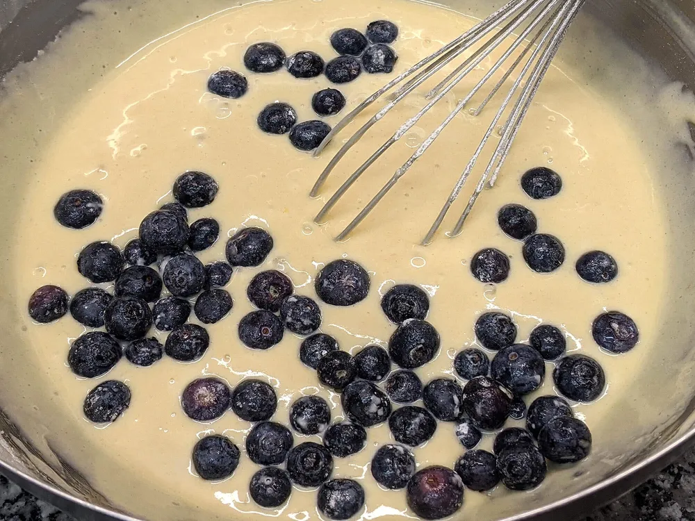 Masa cruda de bizcocho y arándanos.
