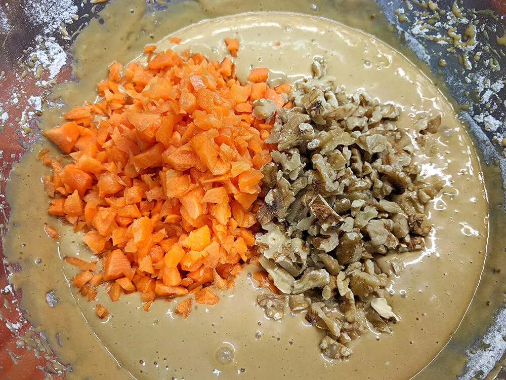 Masa cruda de bizcocho con zanahoria y nueces picadas.