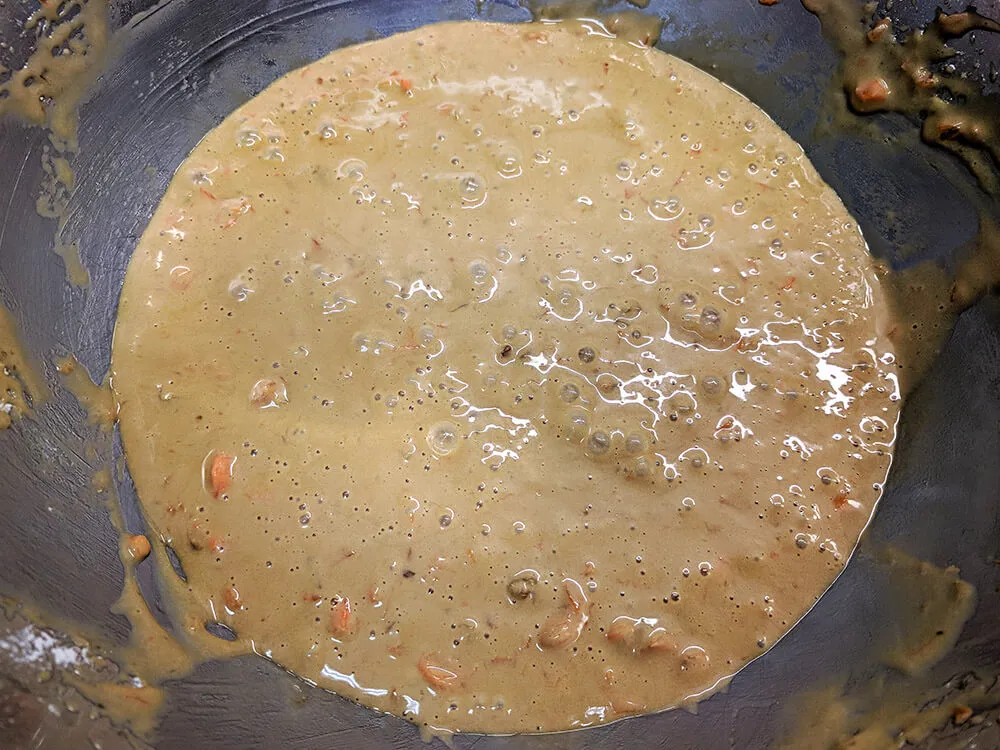 Masa cruda de bizcocho con zanahoria y nueces picadas.