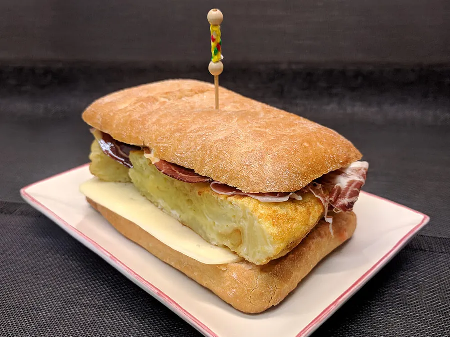 Bocadillo de tortilla de patatas y jamón ibérico.