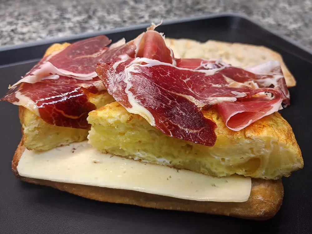 Chapata con havarti, tortilla de patatas y jamón ibérico.
