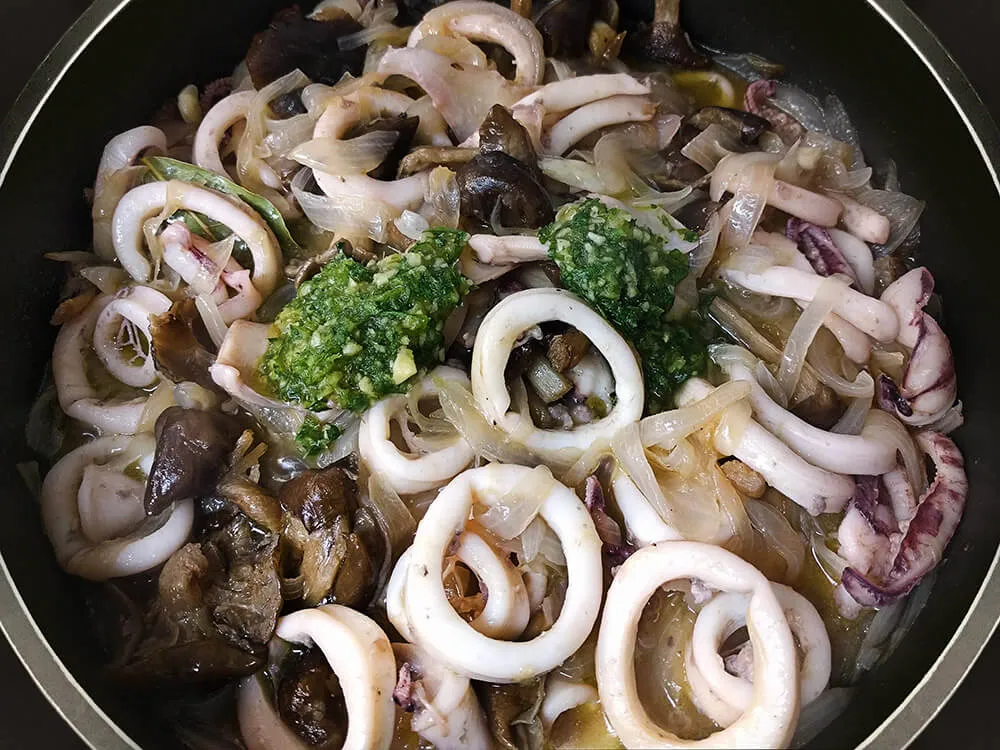 Calamares con cebolla y fredolics y aceite de ajo y perejil.