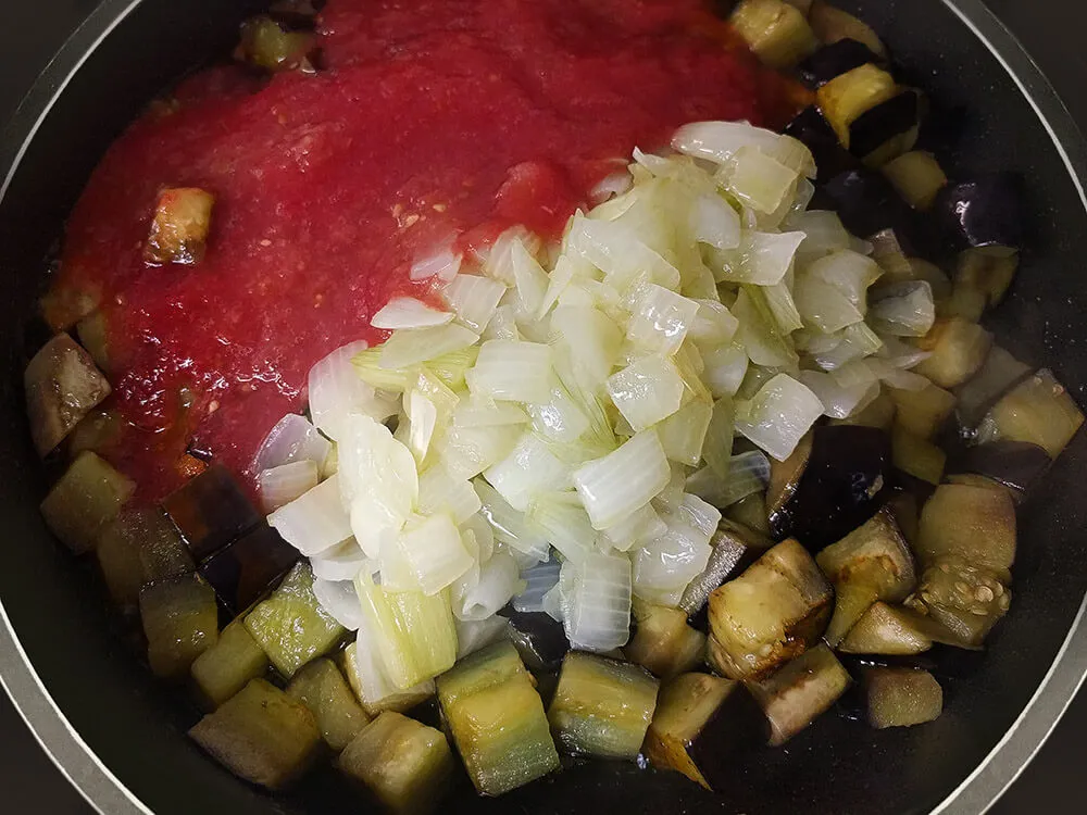 Berenjena y cebolla frita con tomate natural rallado