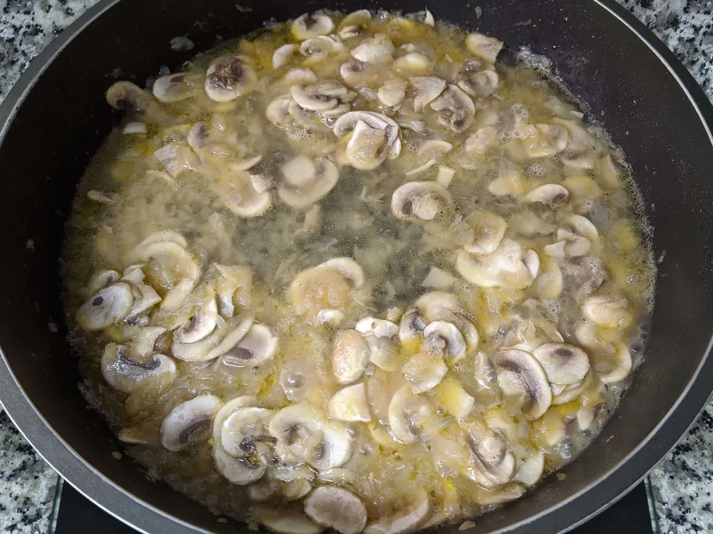 Cebolla y diente de ajo rehogados, champiñones laminados y cava.