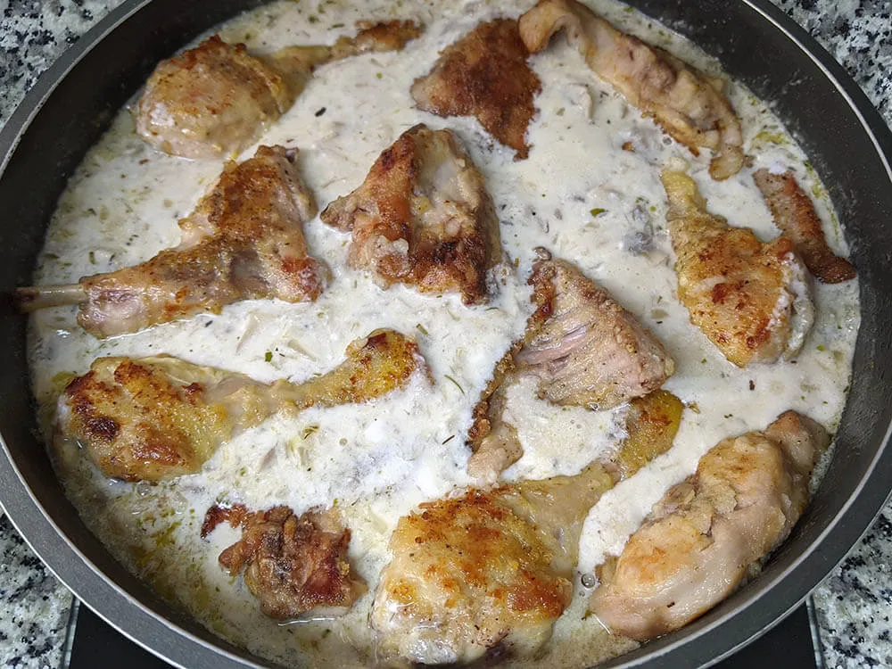 Cebolla y diente de ajo rehogados, champiñones laminados, cava, orégano, tomillo, romero, crema de leche, pollo y conejo.