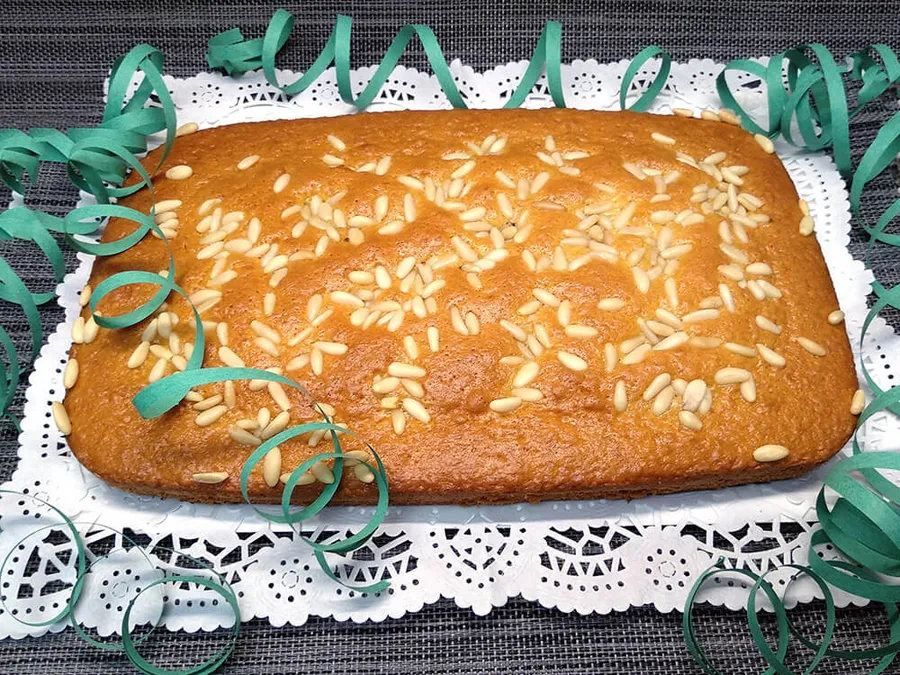 Coca de bizcocho con piñones.