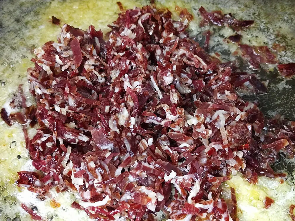 Cebolla pochada y virutas de jamón ibérico