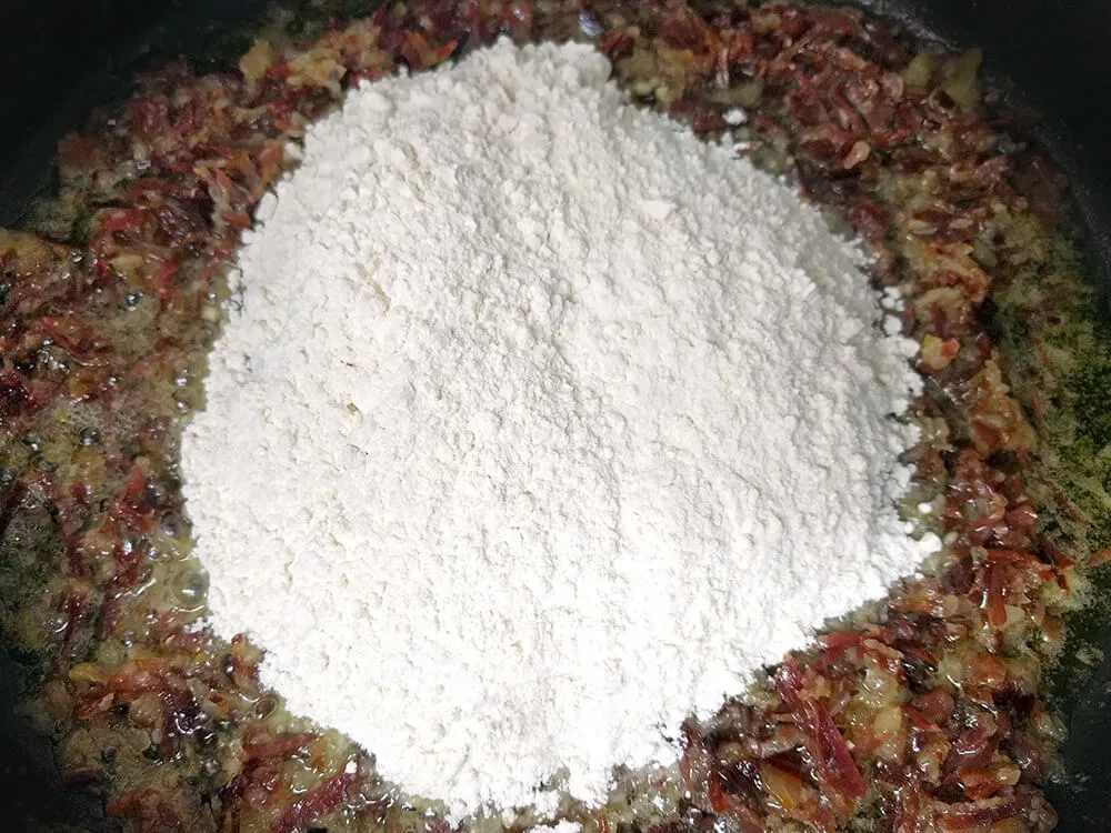 Cebolla pochada, virutas de jamón ibérico y harina