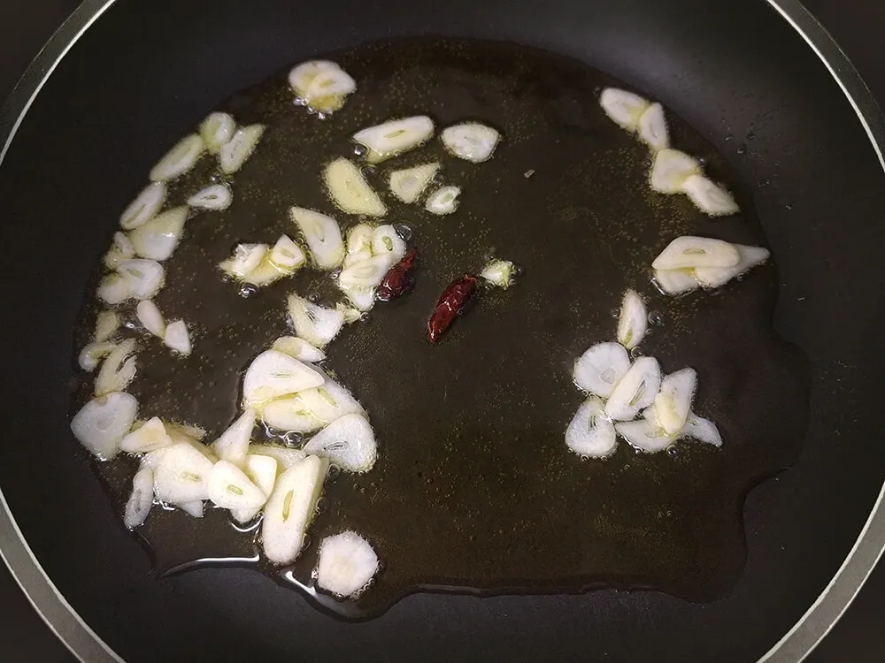Ajos laminados y guindillas rehogándose