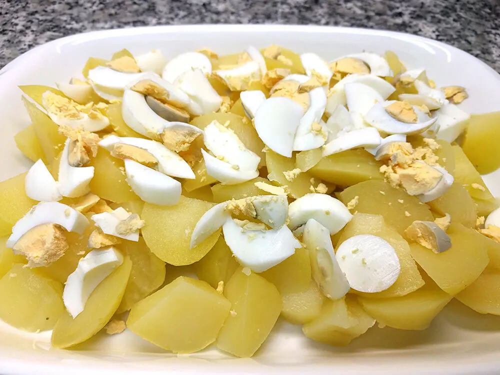 Patatas y huevos cocidos cortados a trozos