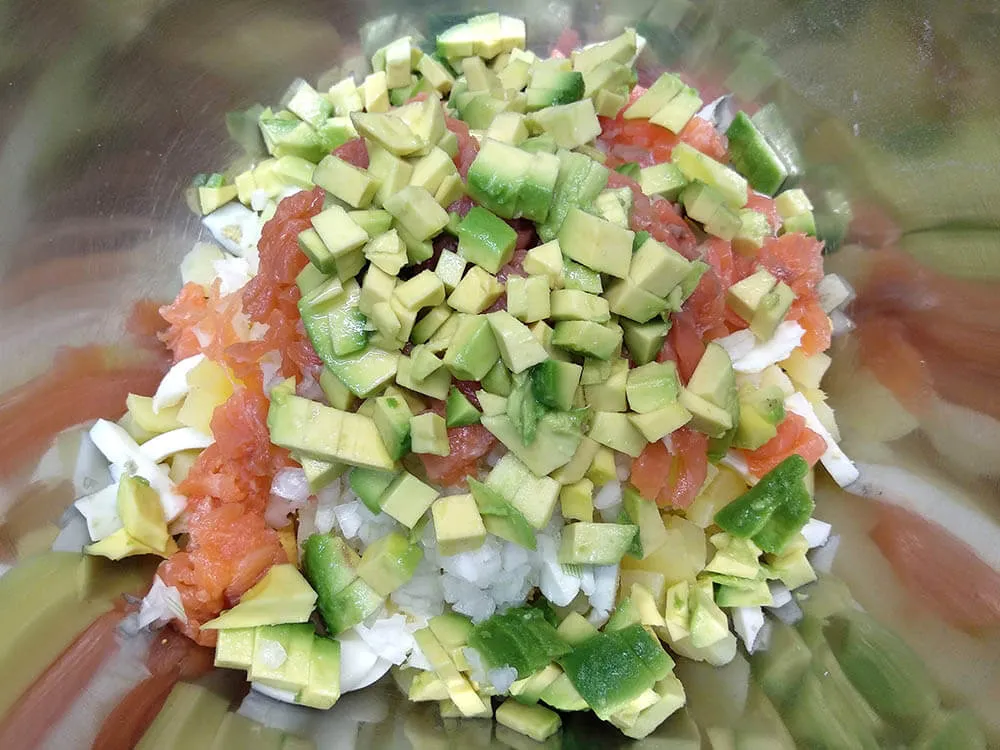 Patata y huevos cocidos, cebolla picada salmón ahumado a tiras y aguacate.