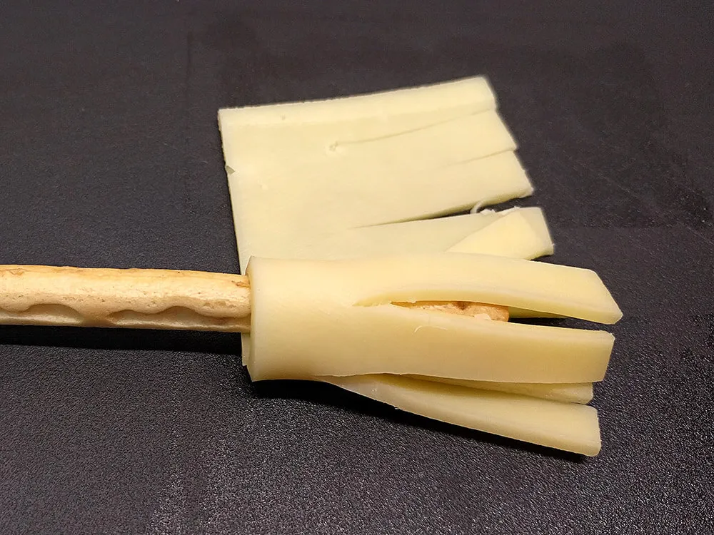 Bastoncito de pan y queso Gouda enrollado.