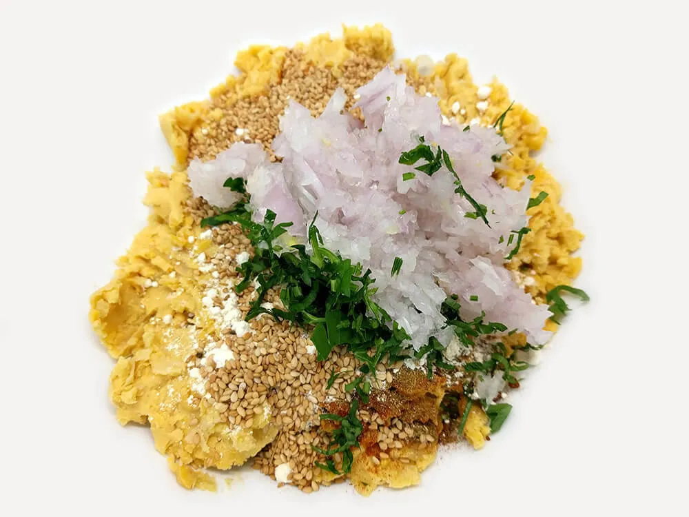 Grabanzos triturados con especias y cebolla picada