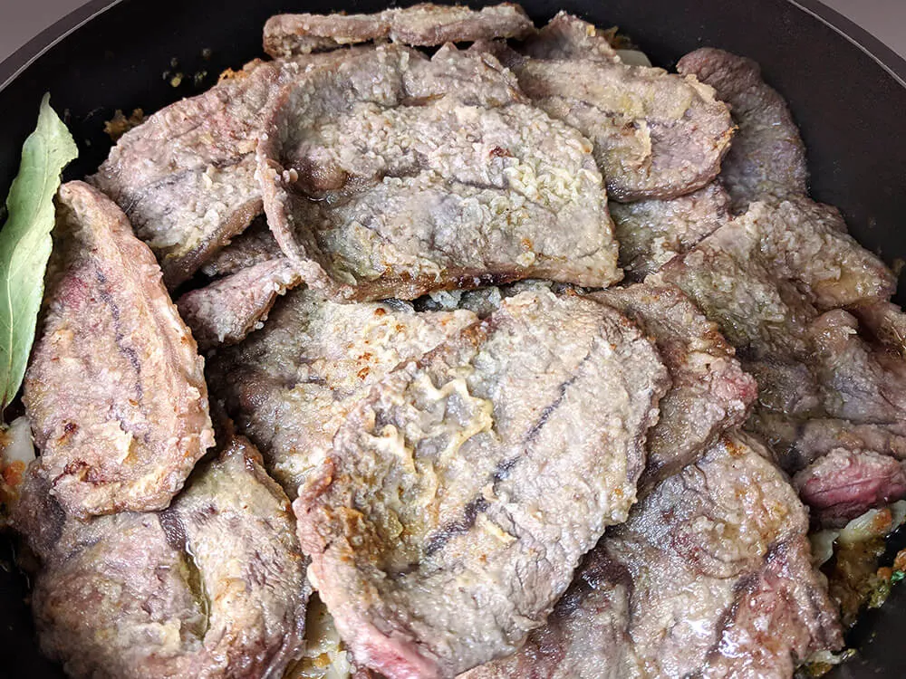 Ternera frita, sofrito y gírgolas.