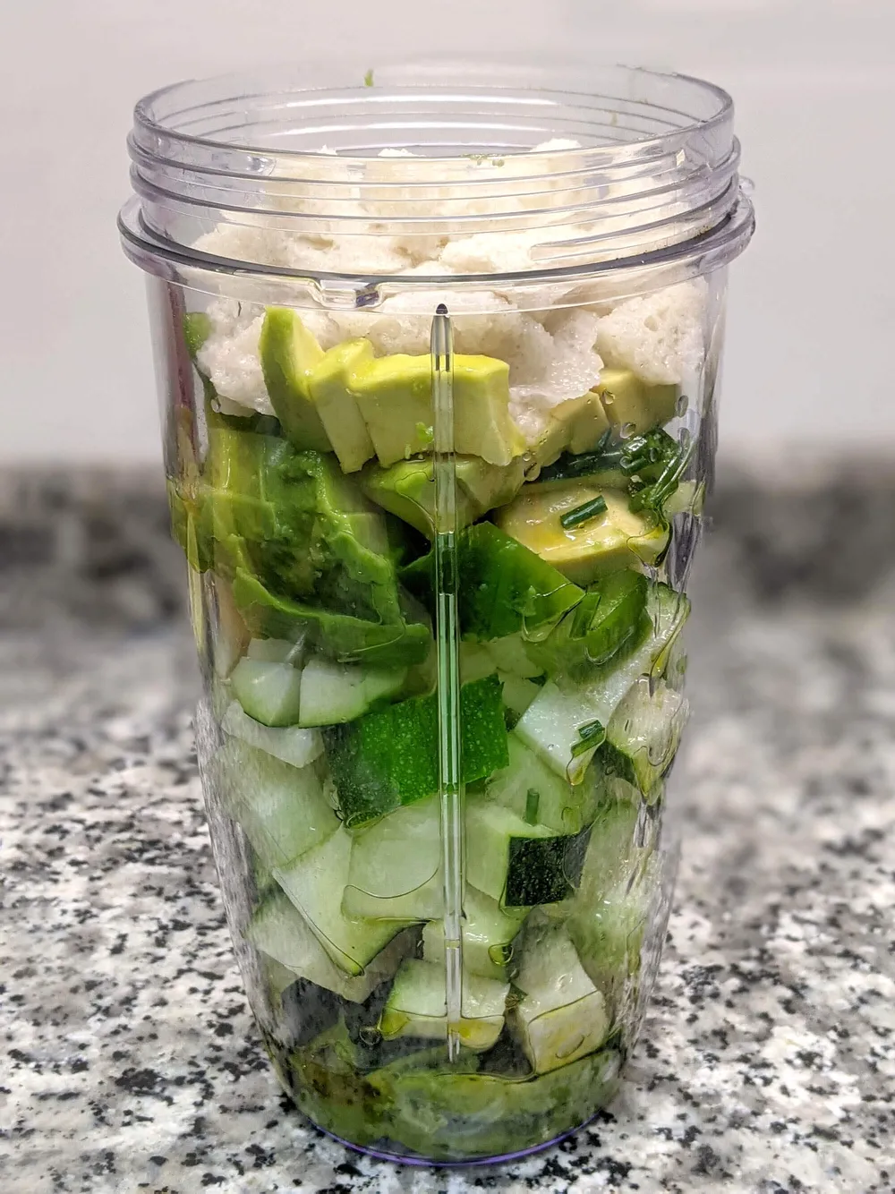 Vaso de batidora con ingredientes cortados.