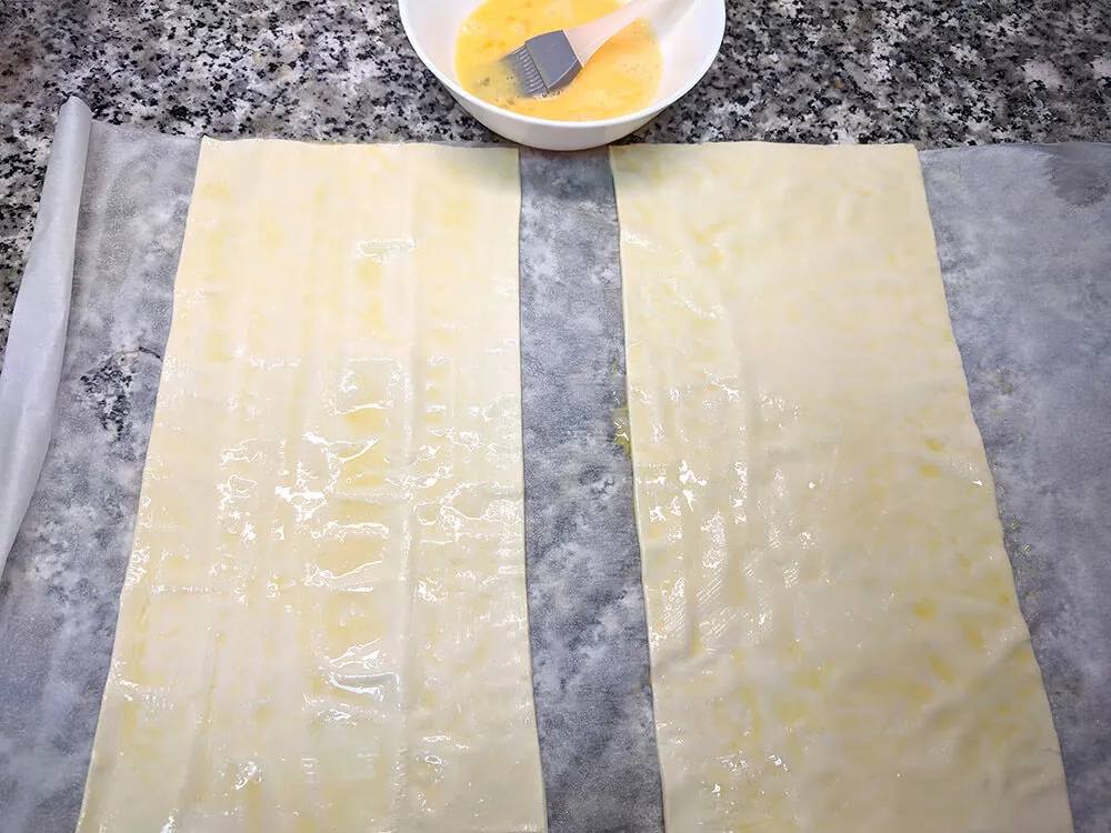 Masa de hojaldre fresca, cortada por la mitad.