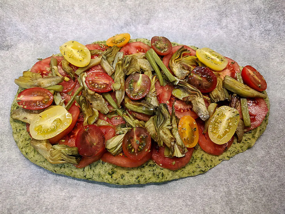 Pan kale con rodajas de tomate de pera, alcachofas y cherry.