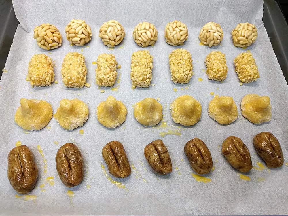 Panellets pintados con yema de huevo listos para hornear.