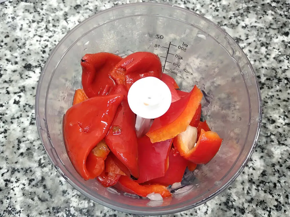 Pimiento rojo y pimientos del piquillo en picadora.