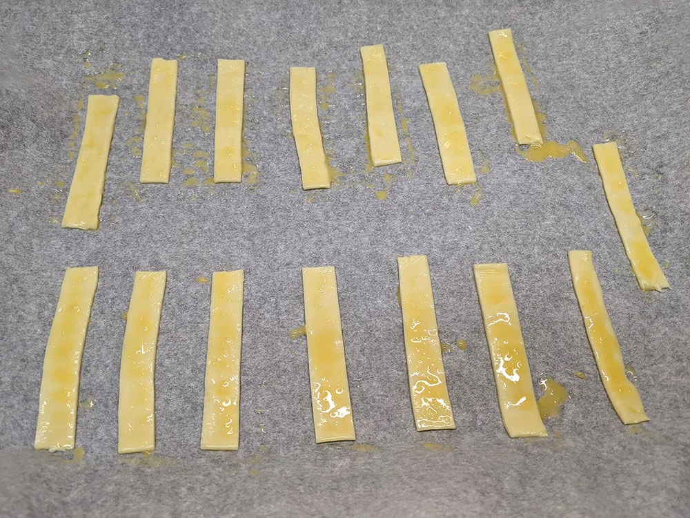 Bastones de hojaldre pintados con huevo batido.