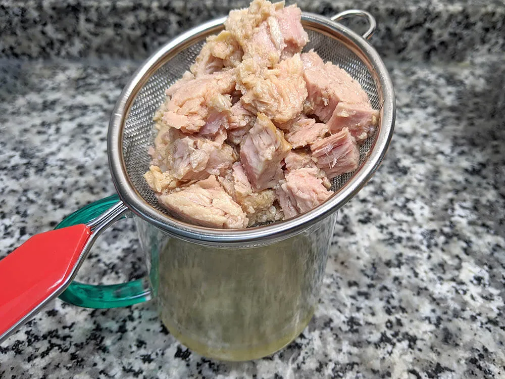 Atún en aceite de oliva en escurridor.