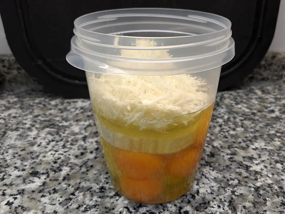 Vaso de batidora con huevos, quesos, sal y pimienta.