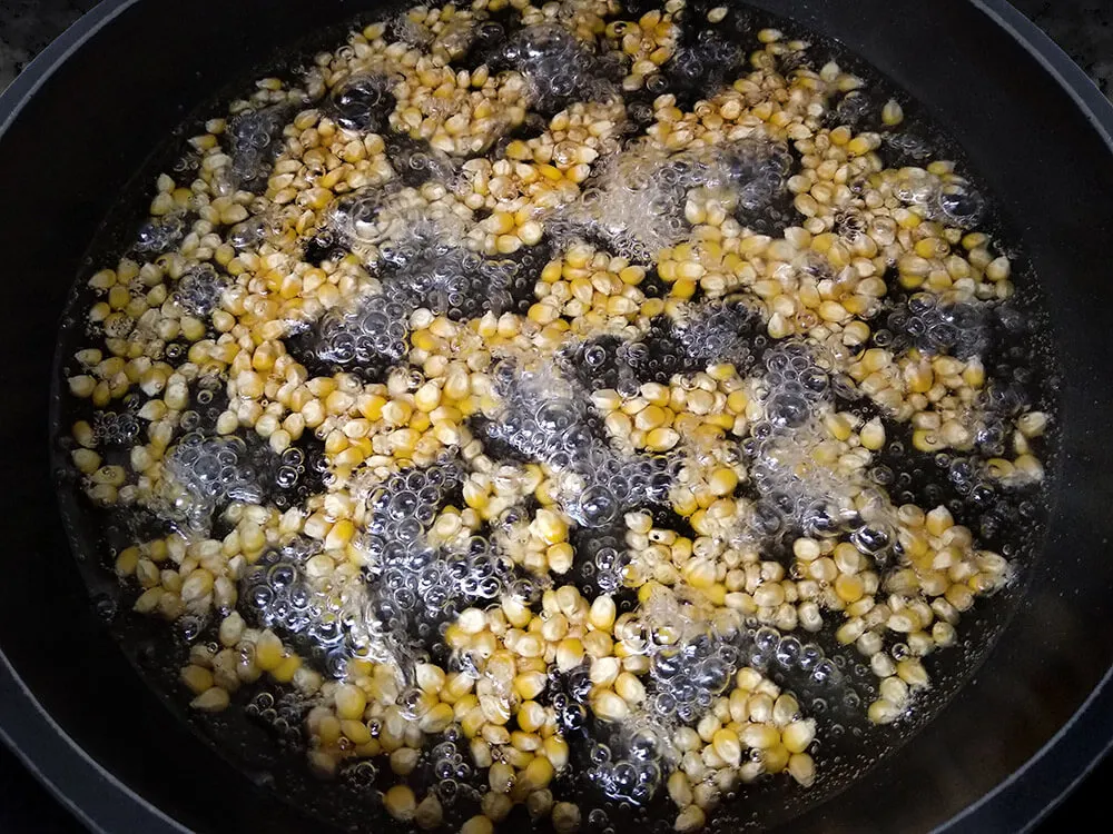 Cazuela con maíz, azúcar, agua y aceite de girasol tapada.
