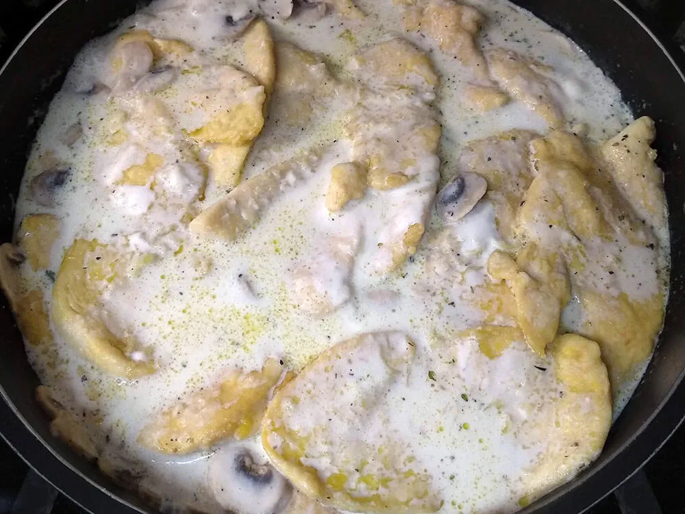 Champiñones salteados con leche, crema de leche y pechugas de pollo.