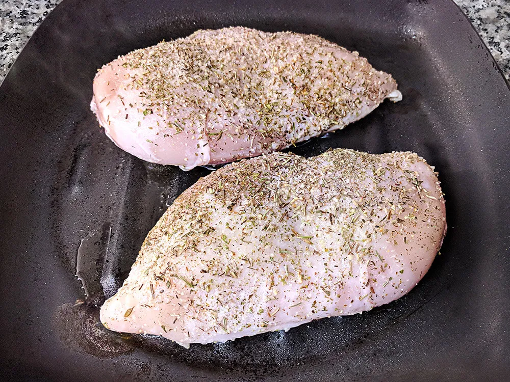 Pollo crudo con oregáno, sal y pimienta.