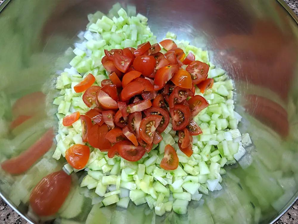 Pepino, pimiento verde, pimiento rojo, cebolla tierna y tomates cherry cortados.