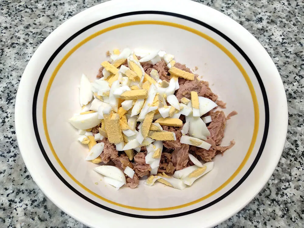 Cuenco con atún y huevos cocidos picados.