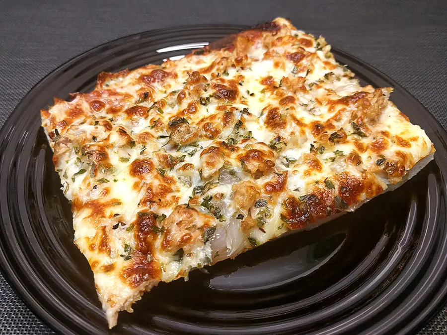 Presentación de la pizza de cebolla, mozzarella y atún.