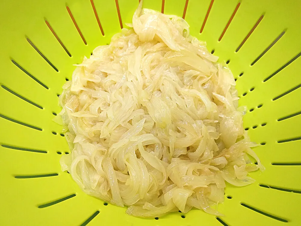 Cebolla frita escurriéndose el aceite.