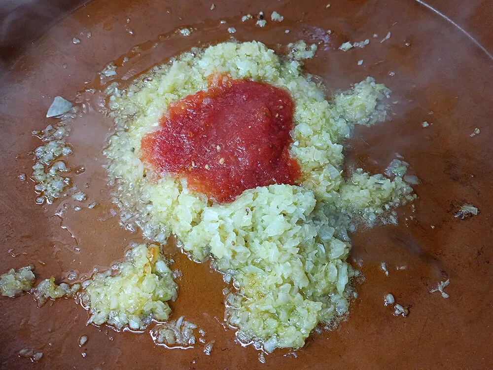 Cebolla pochando y tomate rallado.