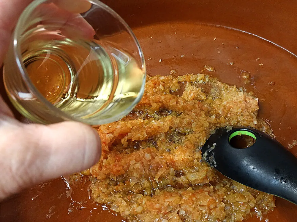 Sofrito y picada cocinados con copa de vino.