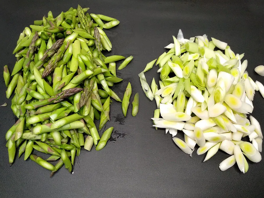 Ajos tiernos y espárragos verdes listos para cocinar.