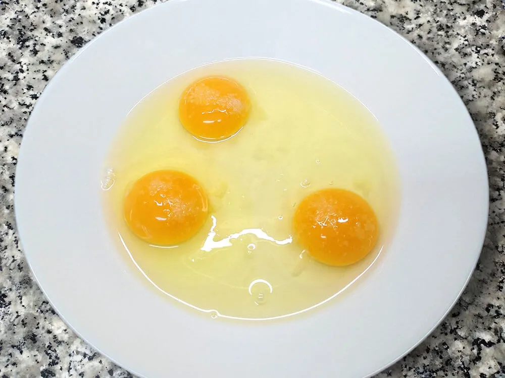 Espárragos verdes y ajos tiernos con aceite de ajo y perejil y huevo crudo.