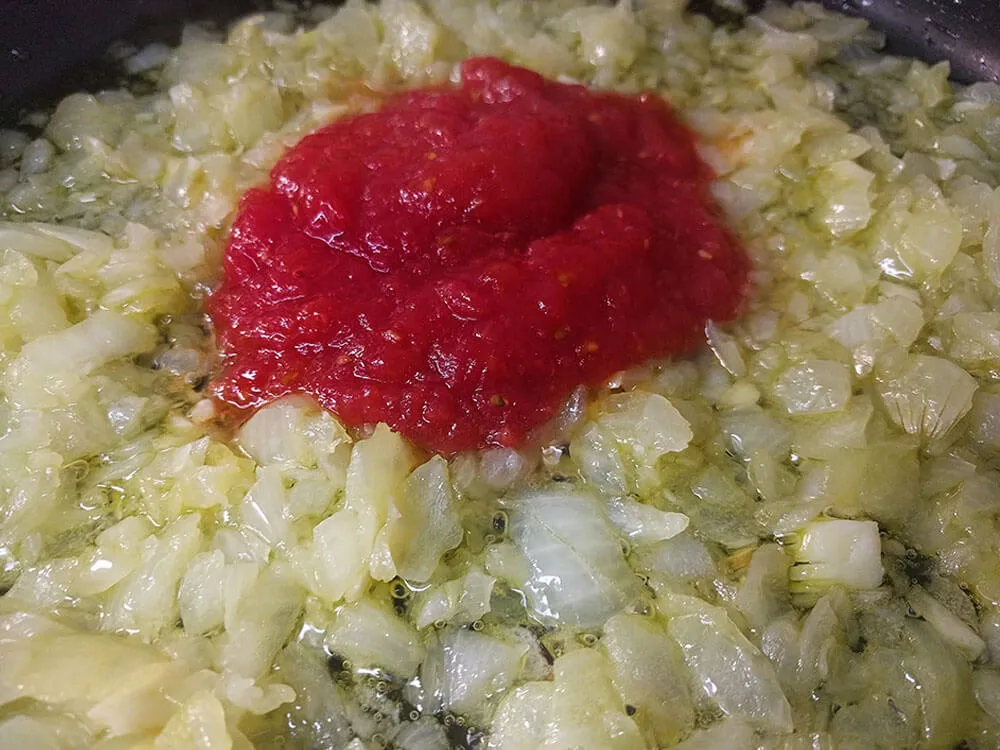 Cebolla y ajo pochados y tomate rallado.