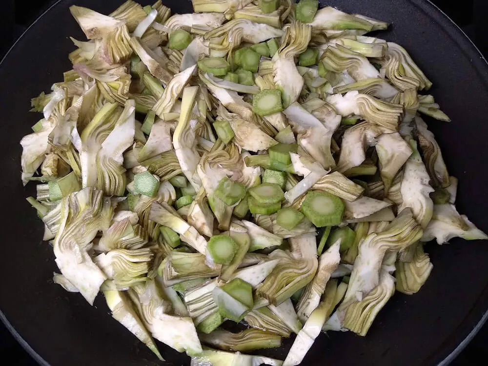 Alcachofas cortadas en sartén.