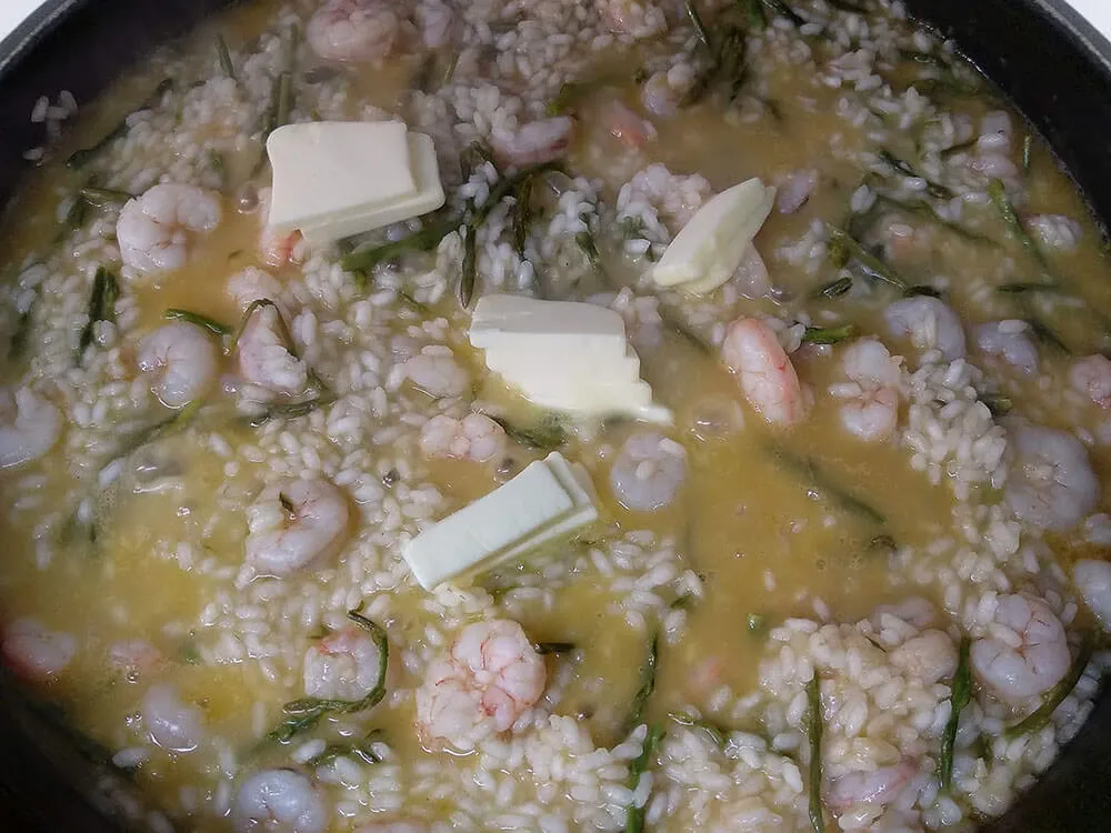 Sofrito, espárragos, arroz, caldo de pescado, gambas y mantequilla.