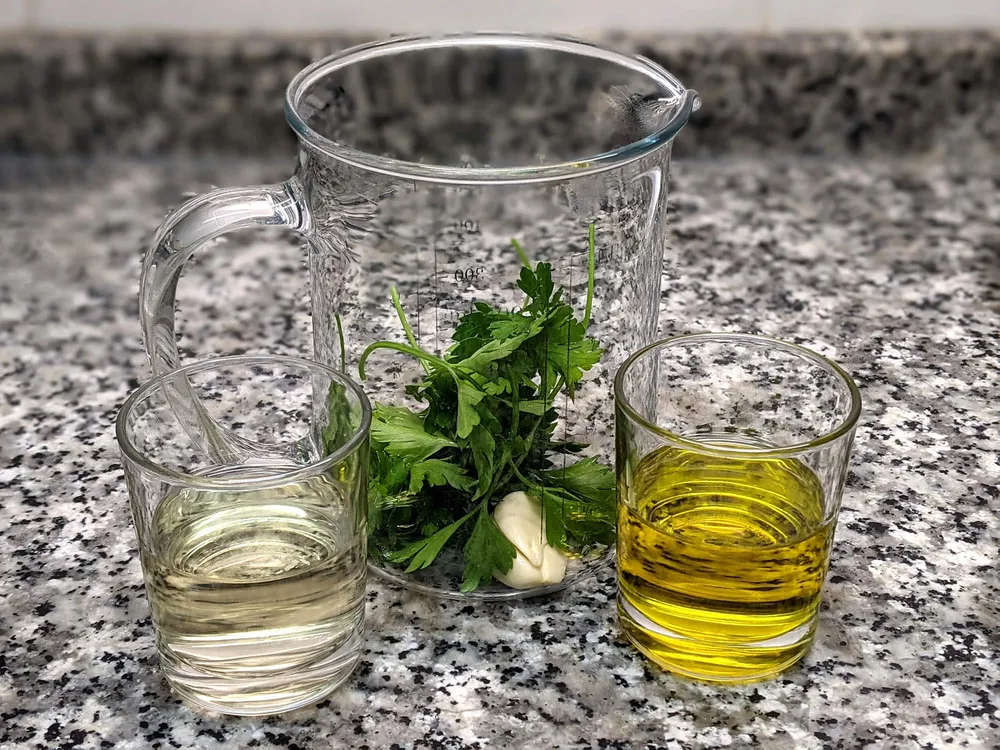 Vasos con vermut, aceite OVE y ajo y perejil.