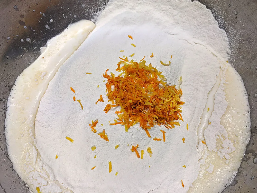 Harina tamizada en cima de huevos batidos.