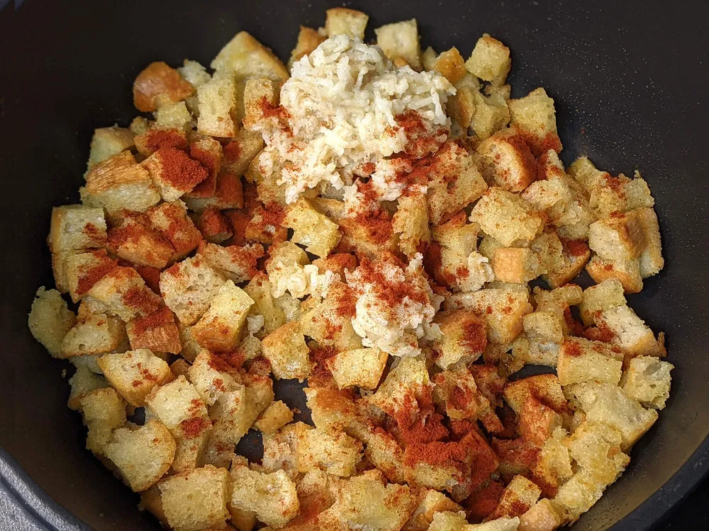 Daditos de pan, ajo chafado y pimentón.