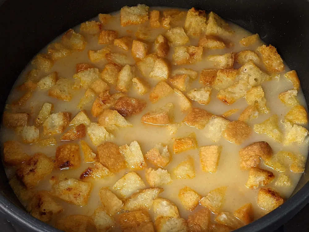 Daditos de pan, ajo chafado, pimentón y caldo.